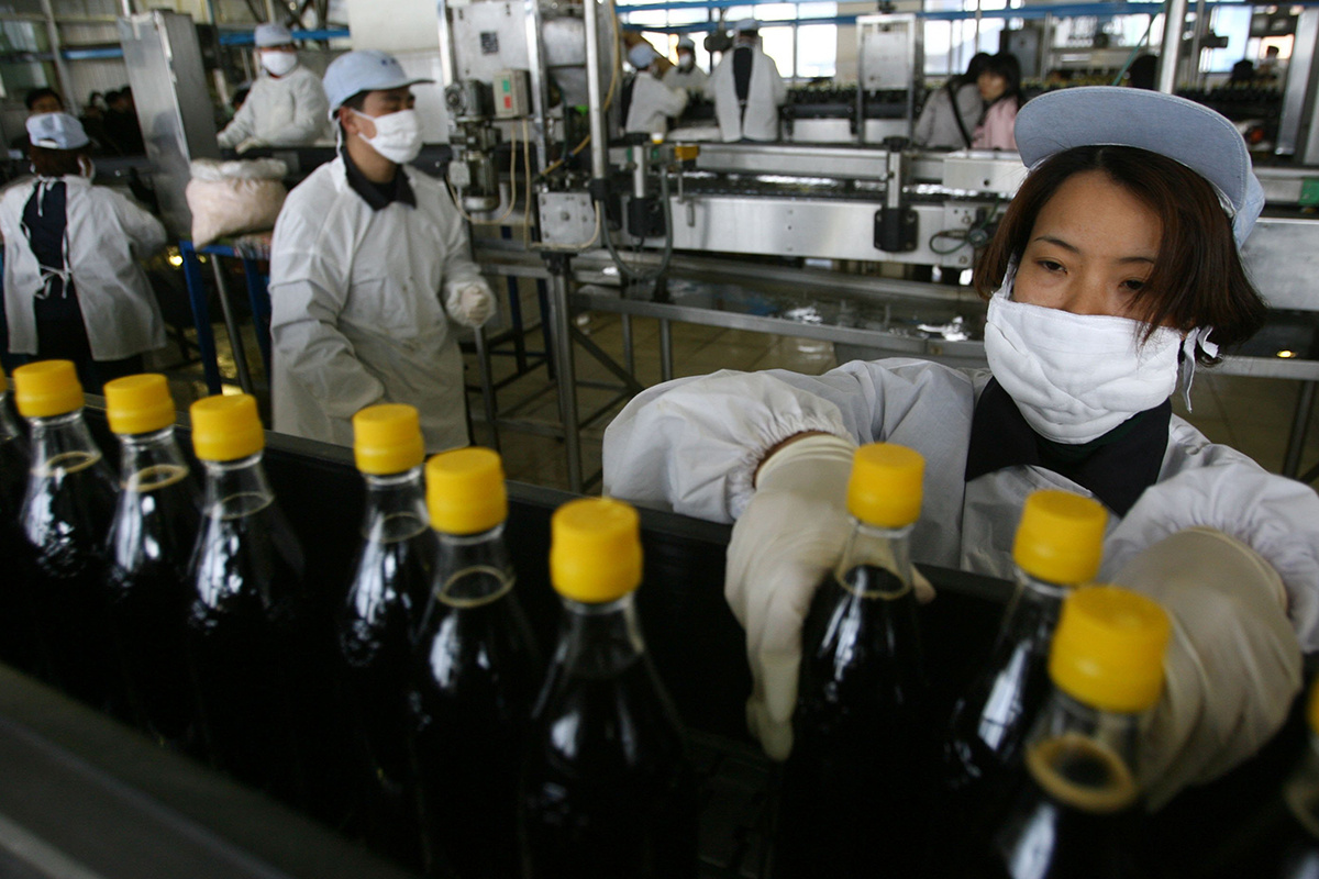 China Photos / Getty Images📷Женщина на производственной линии уксусного завода в Чжэньцзяне, провинция Цзянсу, Китай