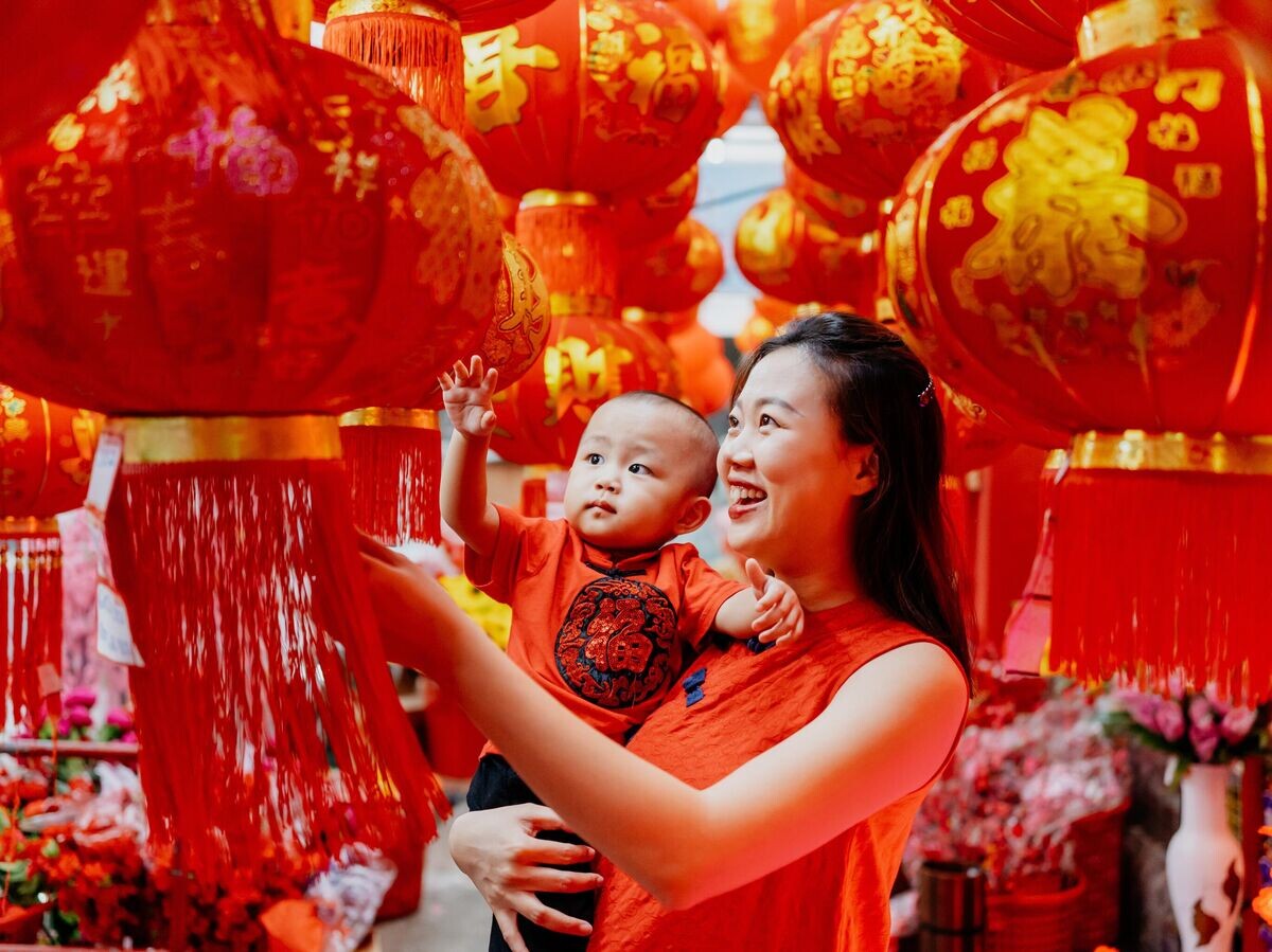    Семья выбирает красный фонарь для празднования китайского нового года | © iStock.com / hxyume