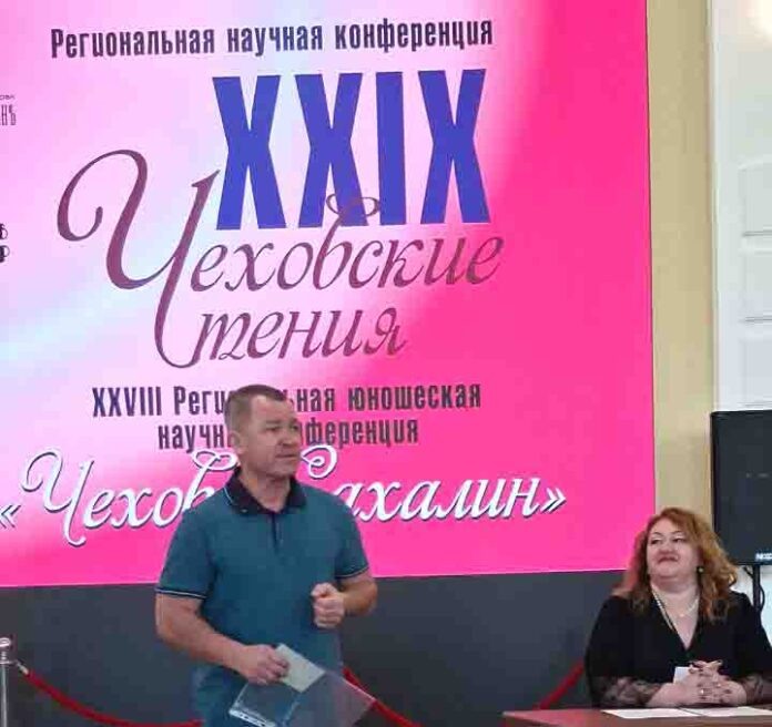 Краевед Сергей Федорчук дарит Евгении Фирсовой дореволюционные открытки с портретом писателя.