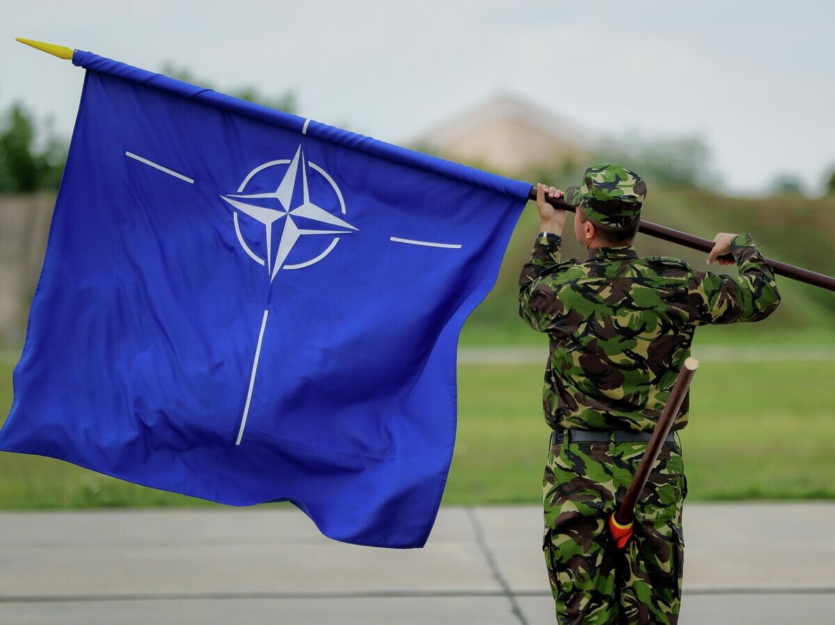    Военнослужащий с флагом НАТО на авиабазе в Румынии | © AP Photo / Vadim Ghirda