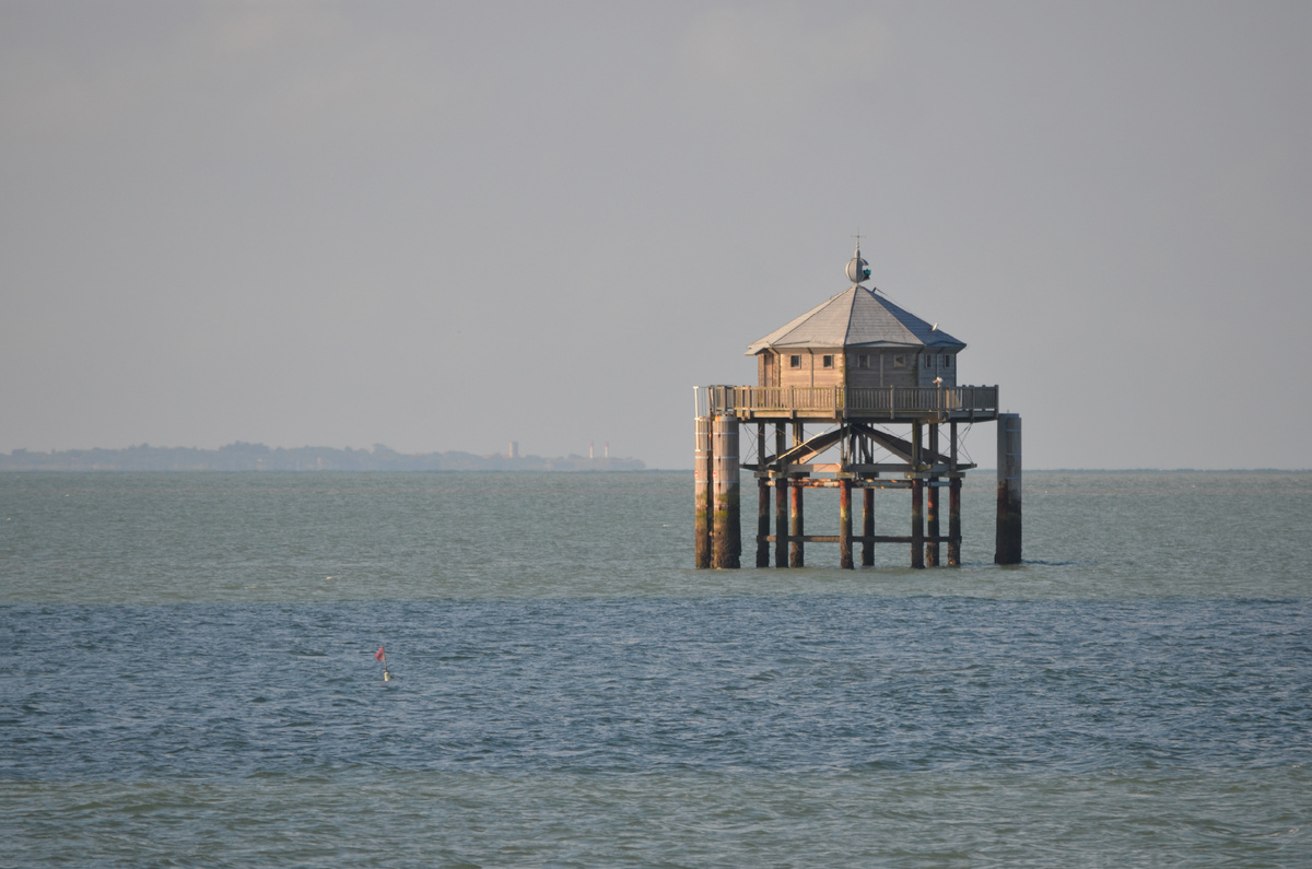 Маяк на краю света и очертания острова Экс на горизонте