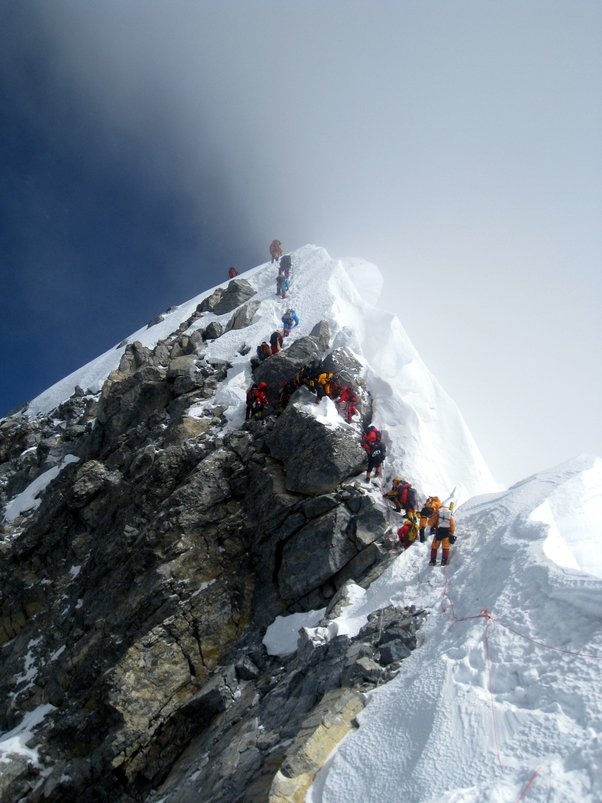 Альпинисты поднимаются (а некоторые спускаются) по Ступени Хиллари. Большая скала в центре — это валун, который упал после землетрясения 2015 г.
