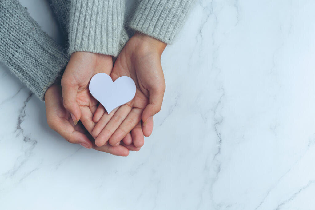    paper heart put in couple's hands on marble table Журналист