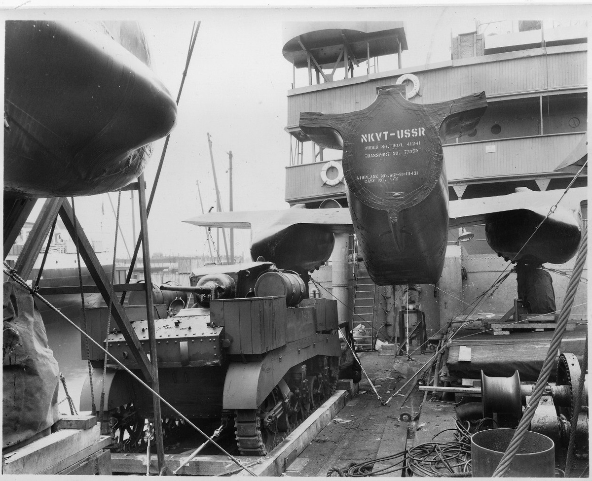 Американский военный груз, приготовленный для отправки в СССР по программе ленд-лиза. На палубе транспортного корабля стоят лёгкий танк М3 «Стюарт» и разобранный самолёт А-20 «Бостон». 1941 год.