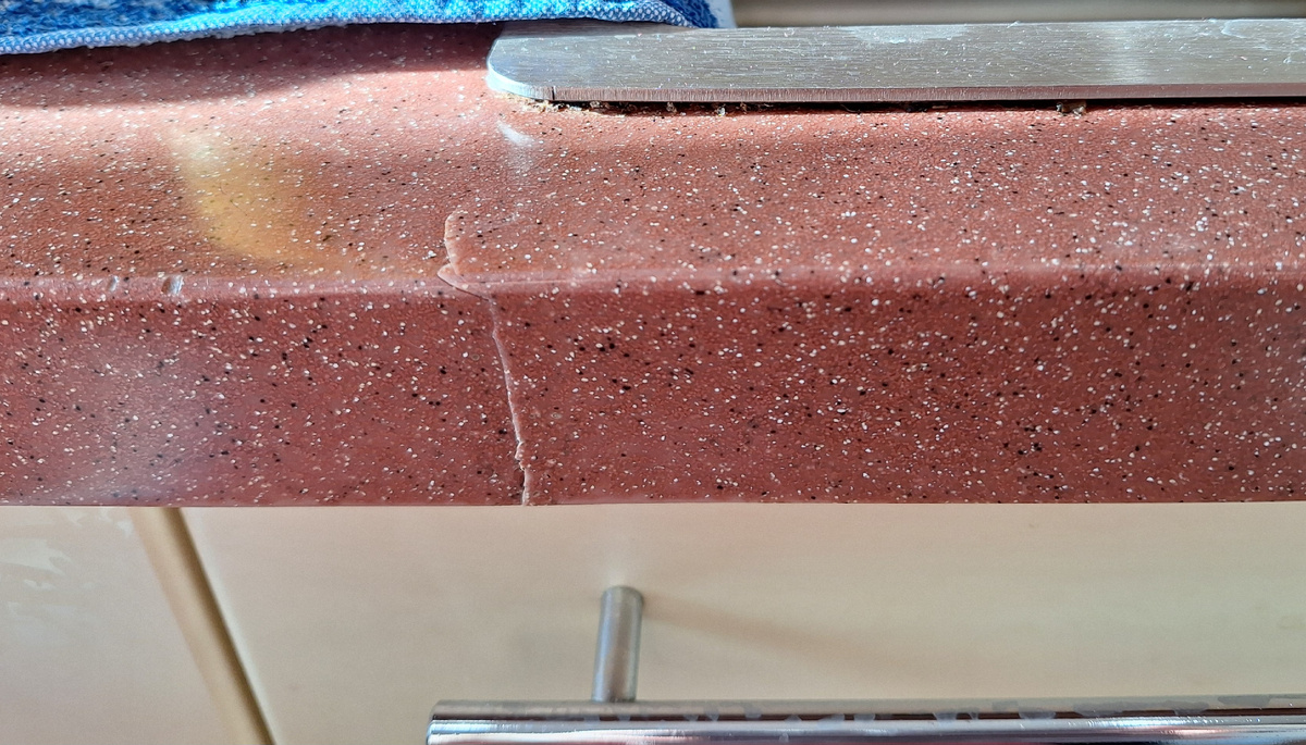 Место состыковки тоже распалось. Рабочие не могли целиком занести столешницу в квартиру. Она сделана буквой Г. Не прошла в узком повороте в коридоре. Её распилили на площадке, занесли, и склеивали уже на месте, потом шлифовали. Запах был ужасный, как же они там, на производстве с этим работают?!