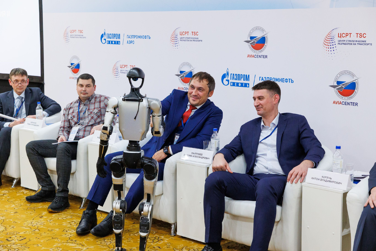 Робот Володя привествует участника конференции