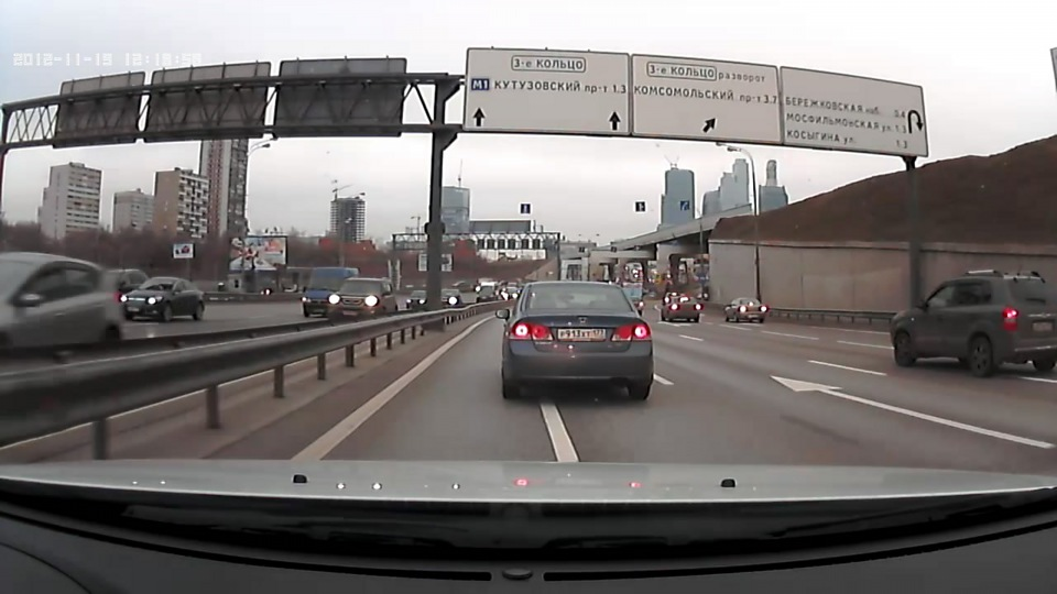 Давайте посмотрим, что происходит с одним и тем же кадром, где проезжает машина с номером, при разном «давлении воды» — битрейте. Скриншоты смоделированы для наглядности, но точно передают суть процесса.

Кадр 1: Низкий битрейт (10-12 Мбит/с для 4K)
Кодеку не хватает данных, чтобы корректно обработать быстро меняющуюся картинку. Там, где должны быть четкие линии букв и цифр, возникает характерное «мыло» или квадратики (артефакты сжатия). Номер «плывет», размазывается. Вы видите просто цветное пятно на том месте, где должен быть номер. Зафиксировать его на такой записи — нереально.