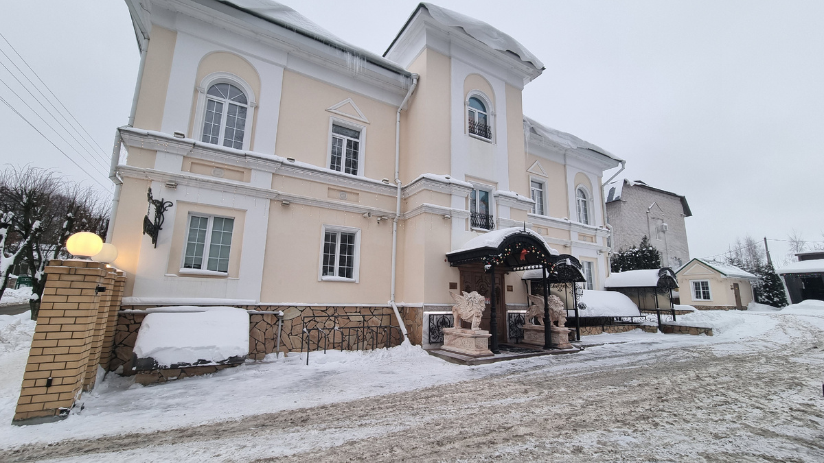 На фото: парковка для авто и здание отеля