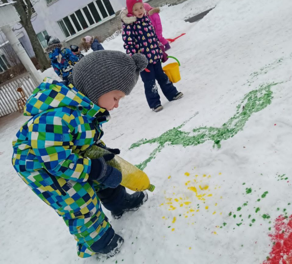 Сын на прогулке раскрашивает снег