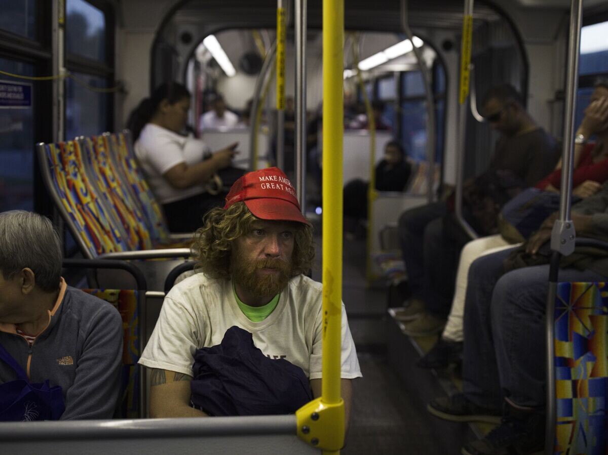    Бездомный в кепке с надписью "Сделаем Америку снова великой" в автобусе в Лос-Анджелесе | © AP Photo / Jae C. Hong