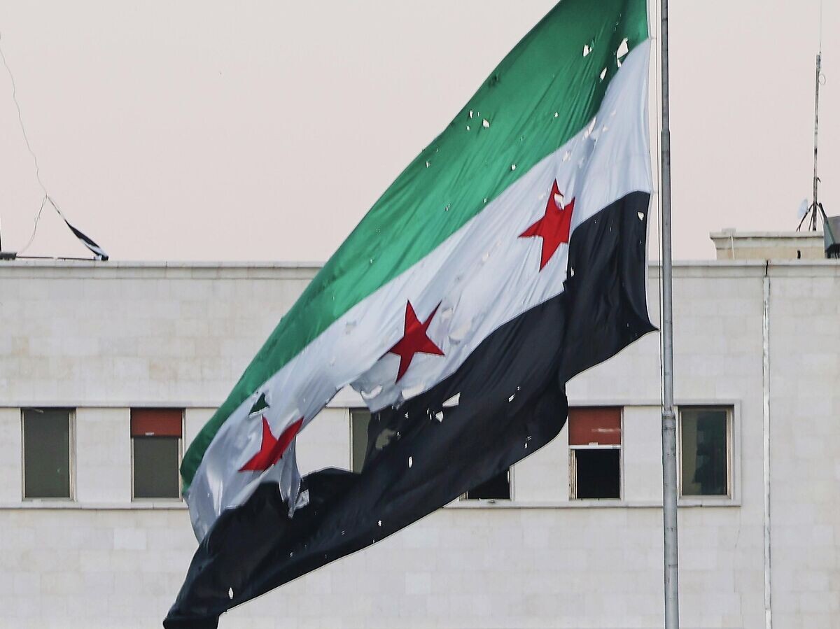    Сирийский флаг у здания Министерства обороны Сирии в Дамаске после израильского удара | © AP Photo / Ghaith Alsayed