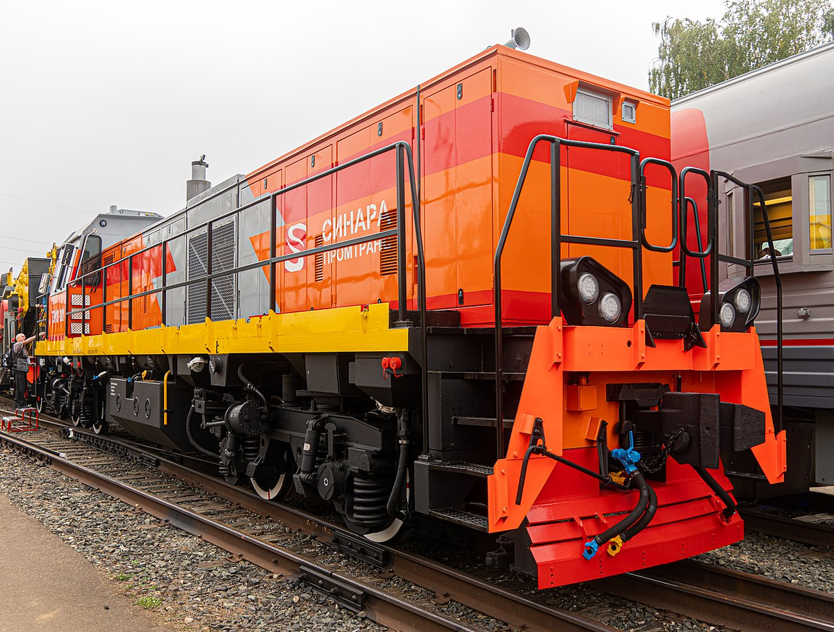 ТЭМ10-001 на железнодорожной выставке «PRO//Движение.ЭКСПО»: вид на большой капот и правый борт (вверху); вид на малый капот и левый борт. Источник фото: ru.wikipedia.org Авторство:  https://commons.wikimedia.org/w/index.php?curid=82668344