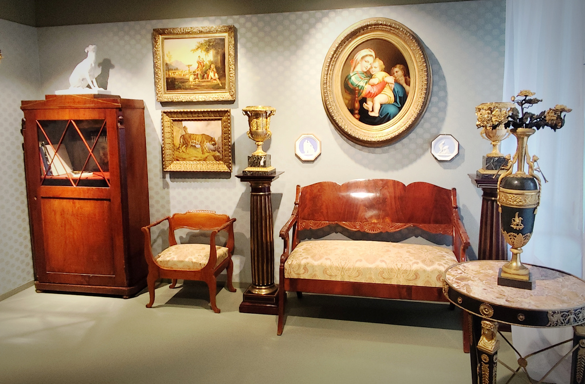 Убранство интерьера в стиле "Бидермейер". Это фамилия выдуманного персонажа, который замышлялся как карикатура на представителей класса буржуазии,  много внимания уделяющих  своему комфорту. Подарил его миру немецкий писатель Людвиг Айхродт