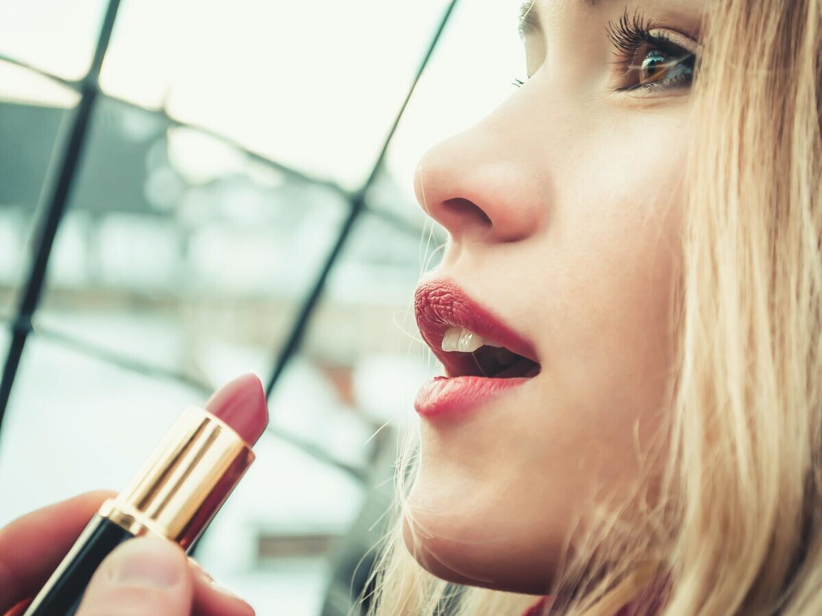    Девушка красит губы помадой | © Фото : Unsplash/Andriyko Podilnyk