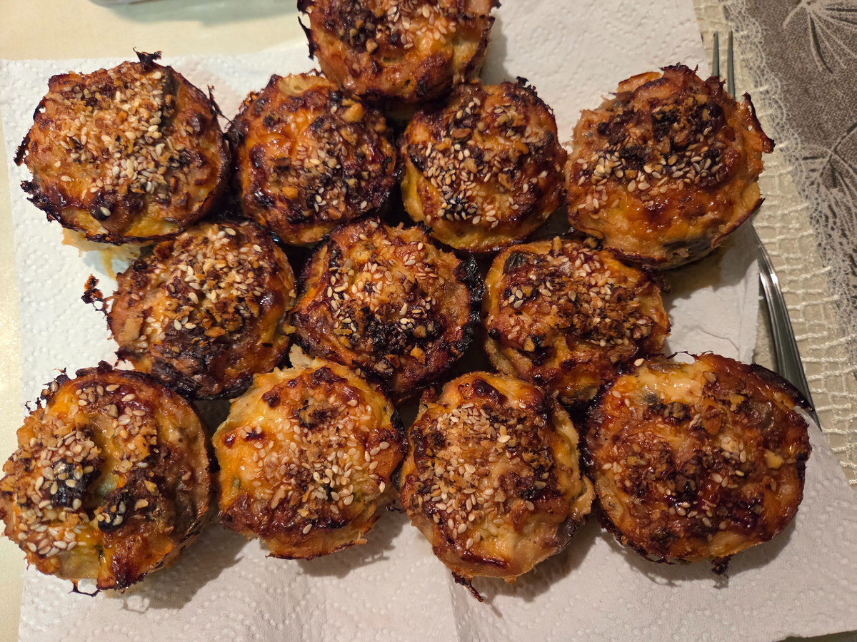 Кексики можно делать мясные и рыбные.. В этот раз делала из курицы: 2 больших бедра без кожи и 2 филе. Всё мелко порубила, добавила пережаренные лук, морковь, грибы (совсем не обязательно грибы, добавьте вяленые помидоры, оливки, кукурузу...), сырые яйца, количество зависит от мяса, у меня 2 яйца С0, большую ложку сметаны, 1ст.л. овсяной муки и 1ст.л. манки без горки, специи обязательно. Хорошо посолила, иначе они невкусные. Хорошо перемешала и отправила в холодильник, стояли несколько часов, готовила на ужин. (Такую массу можно делать и в заморозку, а потом достать разморозить и запекать). Сверху смазала сметаной и посыпала кунжутом и орехами.