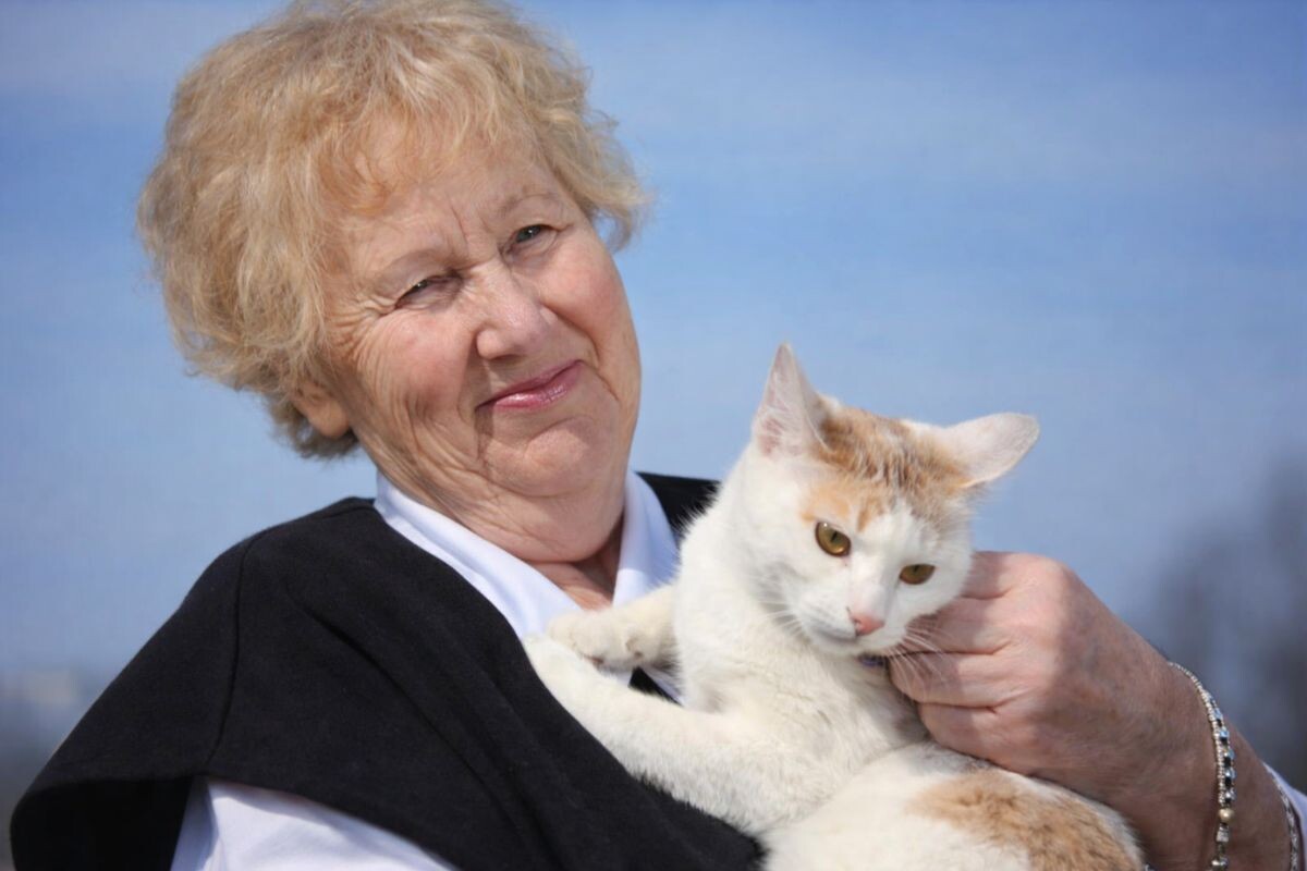 Счастливая пожилая женщина с кошкой 