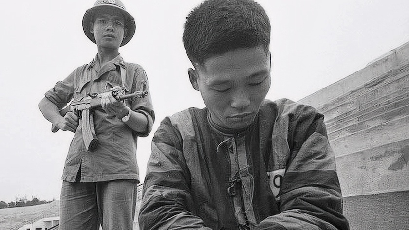 Вьетнамский солдат держит под прицелом военнопленного китайской армии