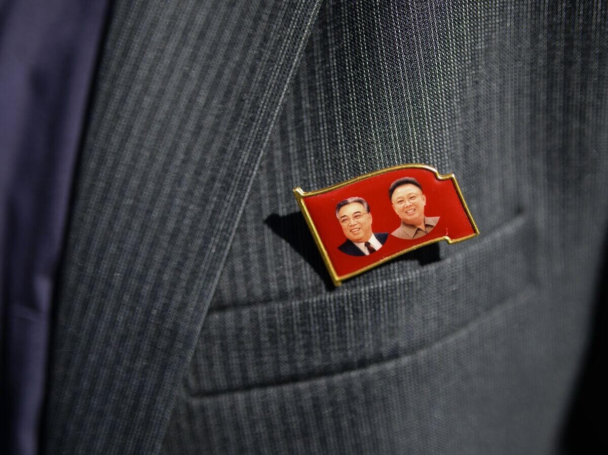    Значок с изображениями Ким Ир Сена и Ким Чен Ира на пиджаке члена корейской делегации | © РИА Новости / Александр Кряжев