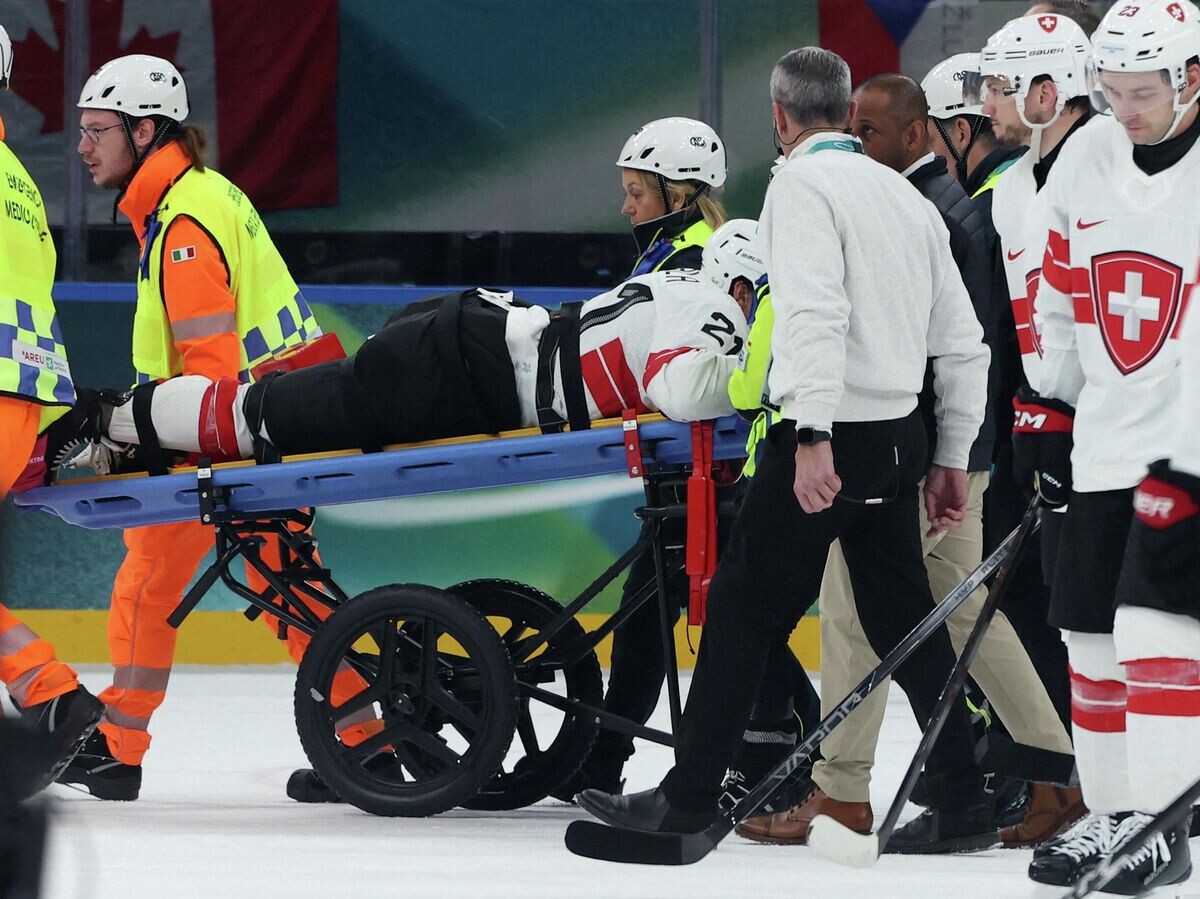    Нападающий сборной Швейцарии Кевин Фиала покидает хоккейную площадку на носилках после полученной травмы | © REUTERS / Mike Segar