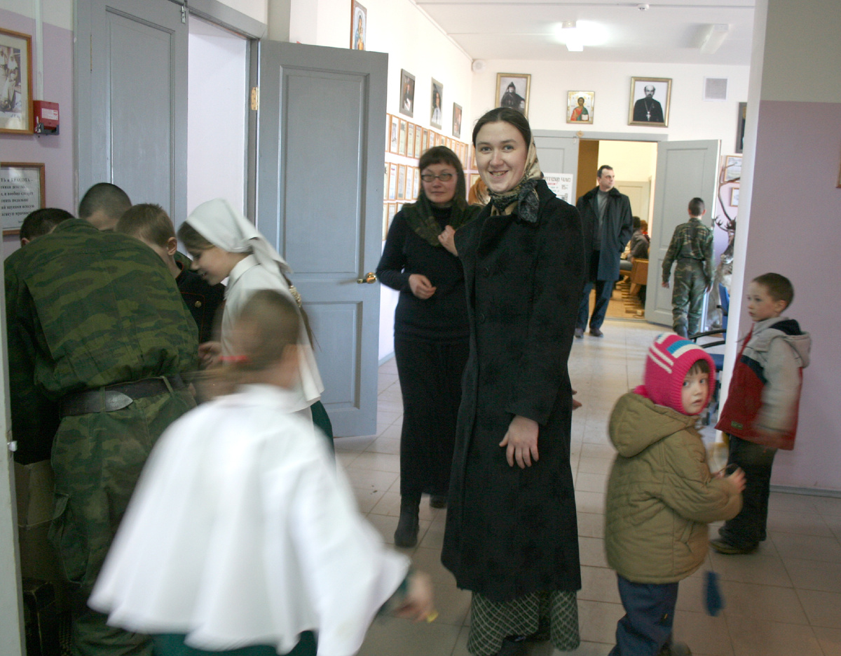 Оля, совсем юная, в красной шапке, рядом с ней Женя, а неподалеку стоит Федя.