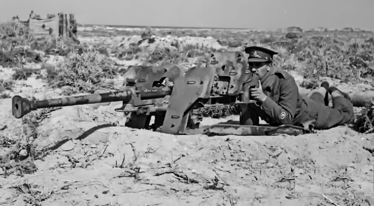 английский военнослужащий целится из трофейного ПТО s.Pz.B.41. Орудие на 1-м типе лафета, колёсный ход отделён.