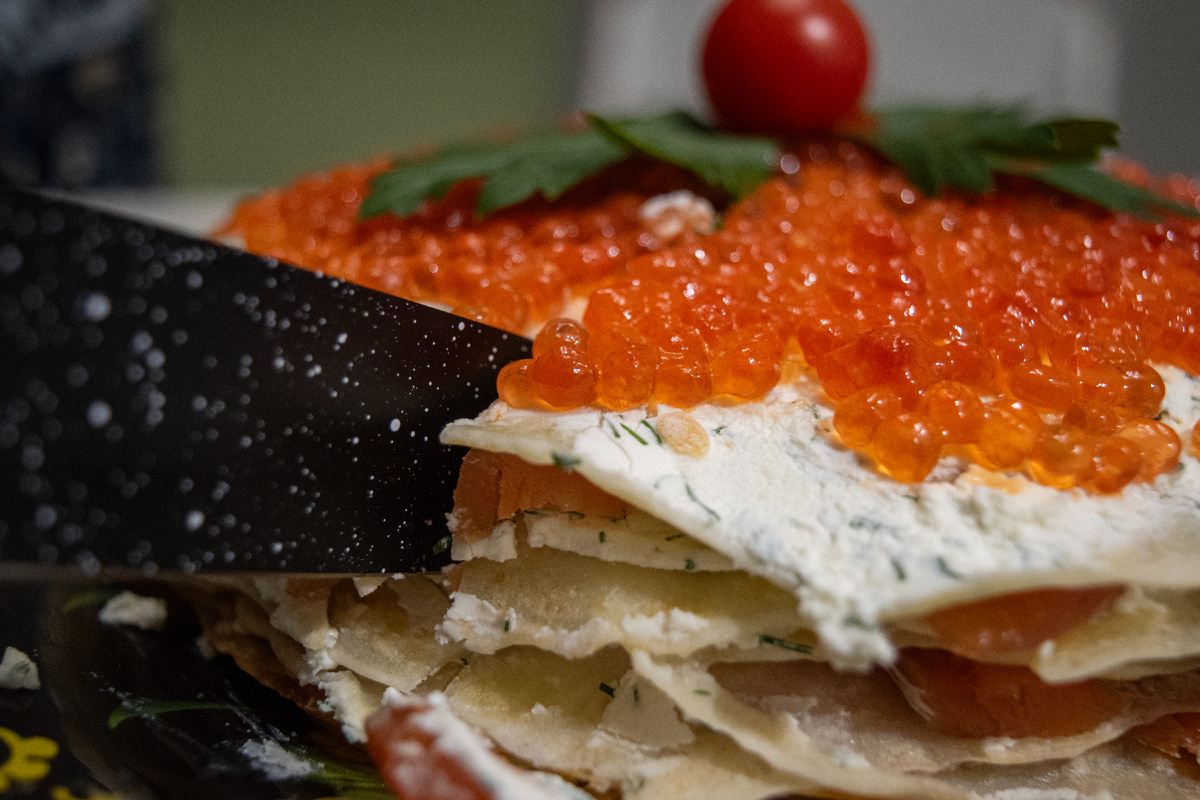 Блины, ломтики рыбы, икра и особая заправка.