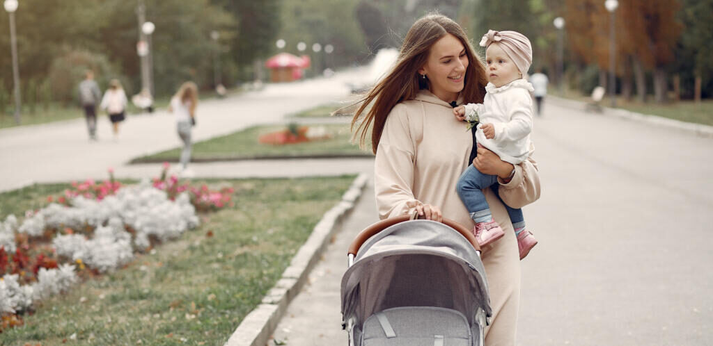    Mother with son. Woman use the carriages. Family in a autumn city Журналист