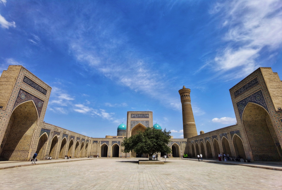 Будто попадаешь в открытую книгу Востока: просторный двор залит мягким солнцем, над головой — бескрайнее синее небо с окутанными мазками облаков.
