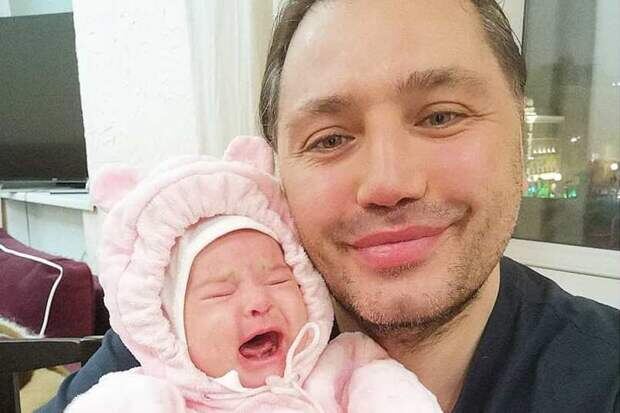 Рустам Калганов держит на руках ребенка