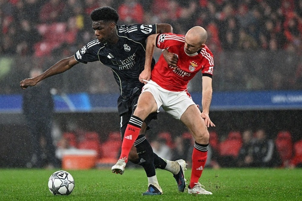    Матч общего этапа "Бенфика" - "Реал" (4:2). В борьбе игрок гостей Орельен Тчуамени (слева) и Фредрик Эурснес. / Getty Images