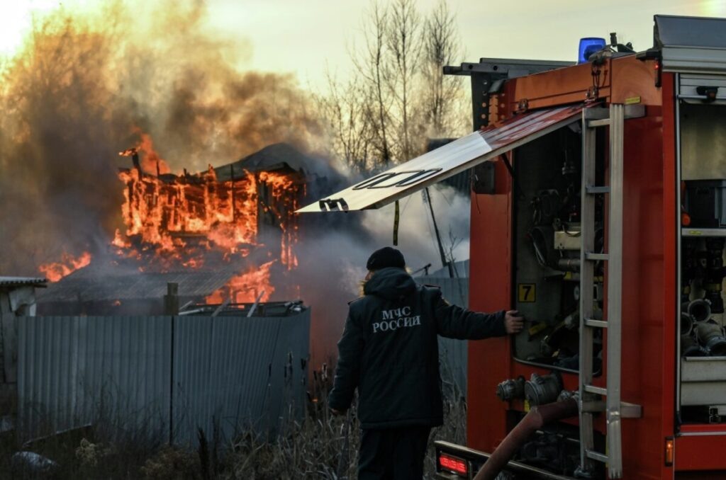 Сотрудник пожарной службы МЧС РФ на месте пожара в частном доме в деревне Ближние Прудищи в Московской области. Фото: Юрий Кочетков / РИА Новости