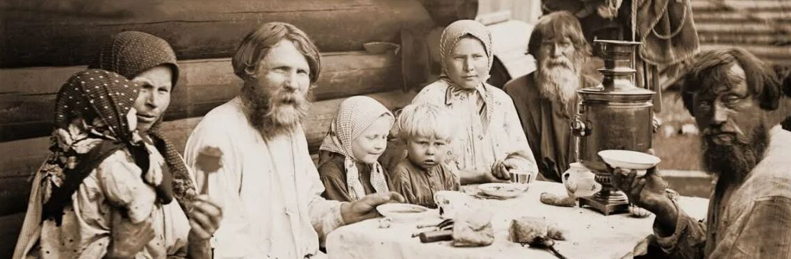 Типичная семья начала XX века. Несколько детей, на столе хлеб да квас. 