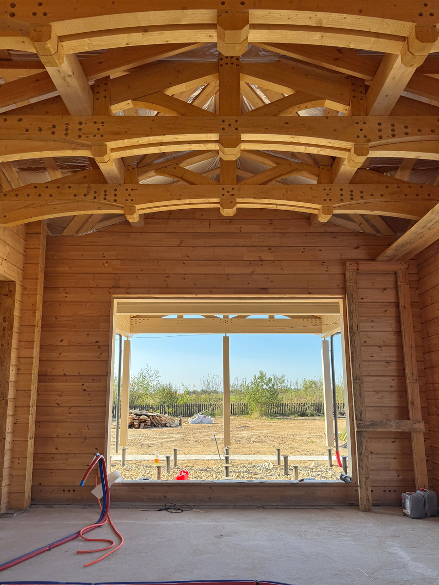 Столовая в деревянном доме с эффектными балками и видом на гольф поле