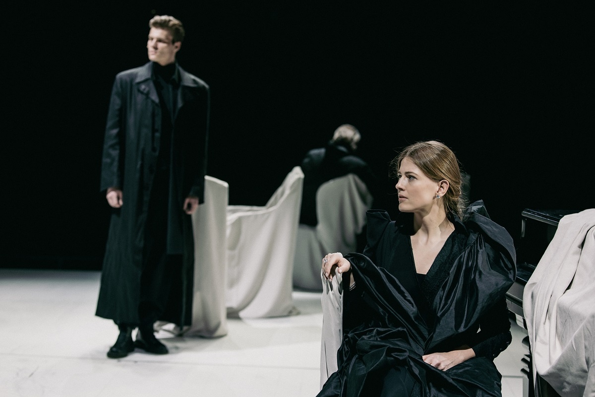    Действие спектакля разворачивается в чёрно-белом пространстве, поделённом на две зеркальные части