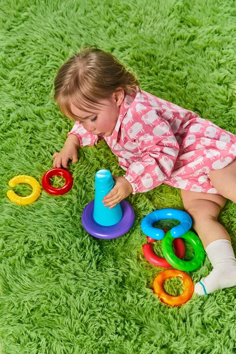 Ребенок сидит играет с игрушкой-пирамидкой 9 месяцев