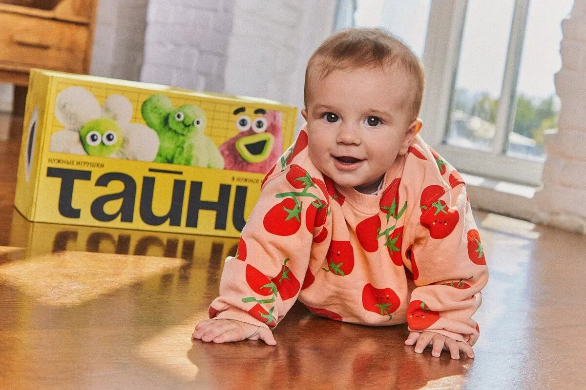 Малыш играет возле Тайни-бокса с развивающими игрушками