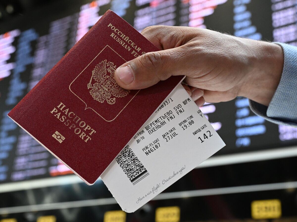    Пассажир держит в руках паспорт гражданина РФ и билеты в международном аэропорту Шереметьево | © РИА Новости / Пелагия Тихонова