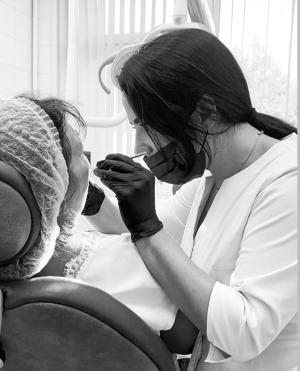 Стоматолог проводит осмотр пациента