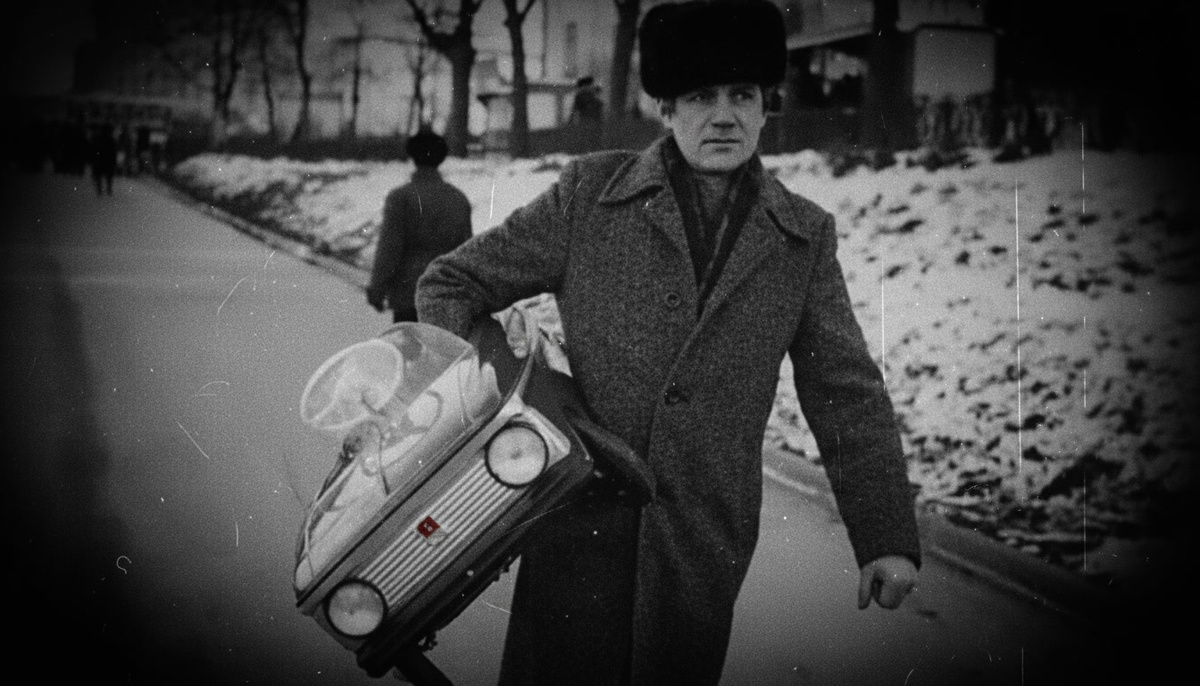 Мужчина с педальным детским автомобилем в руках