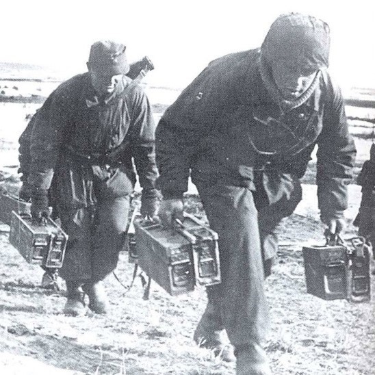 Подносчики боеприпасов тащат патроны и запасные стволы к МГ.