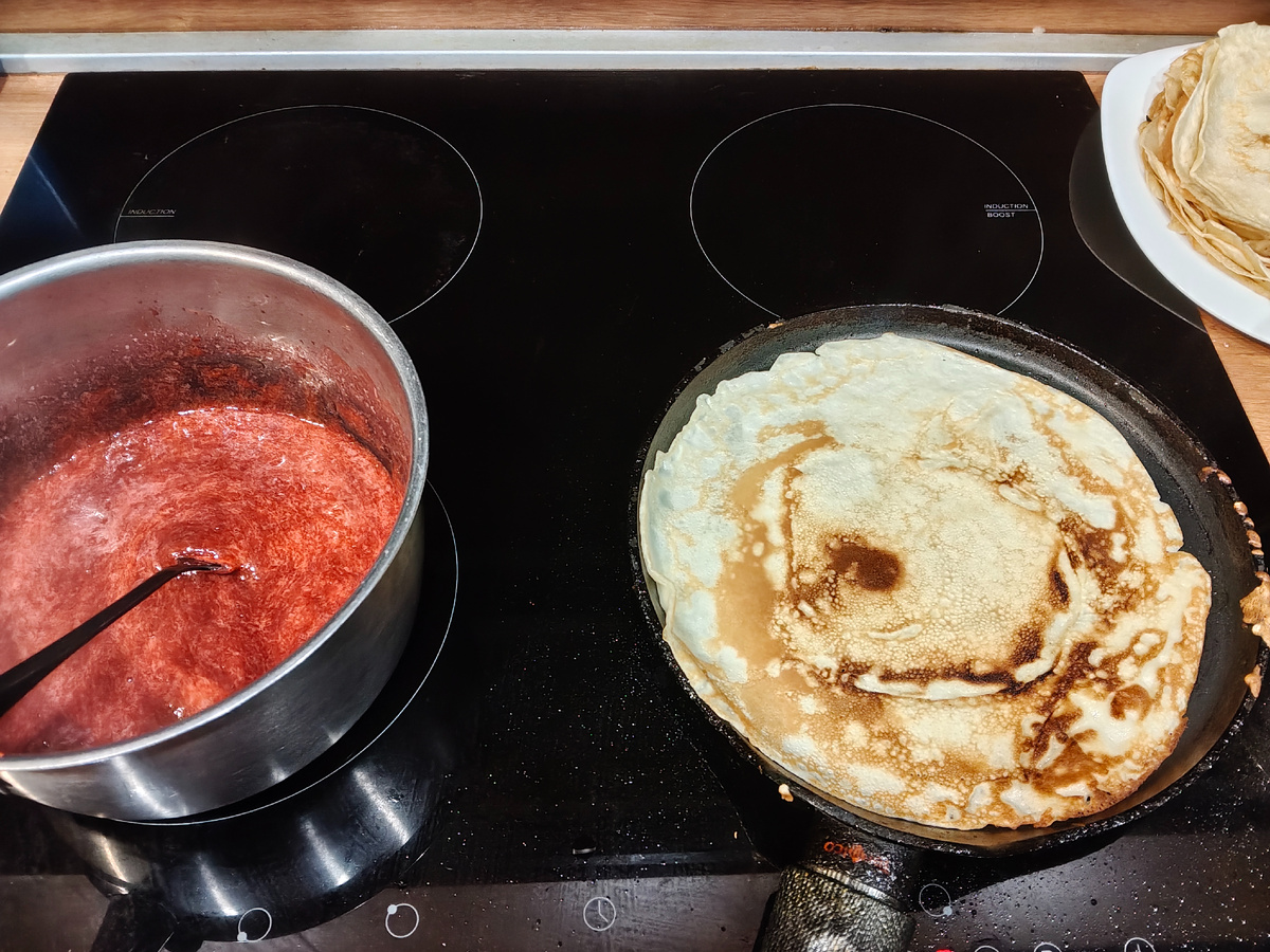 Клубнику разминаем вилкой и продолжаем уваривать до получения густого соуса