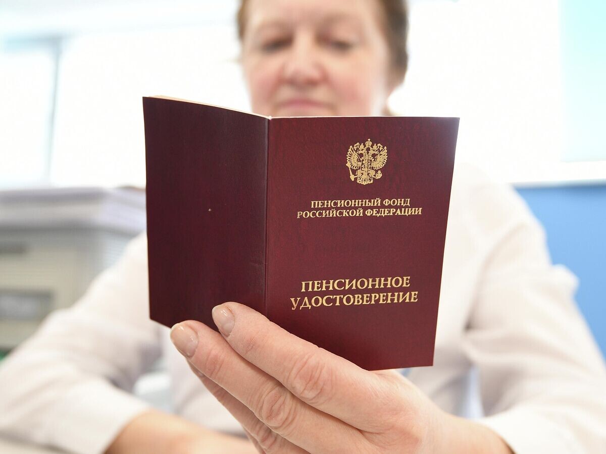    Сотрудник ПФР держит в руках пенсионное удостоверение | © РИА Новости / Максим Блинов