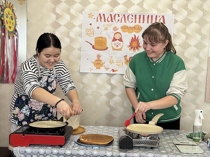 Две девочки пекут блины