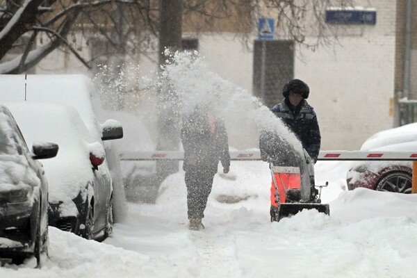 Сотрудники коммунальных служб убирают снег с во дворе жилого дома во время снегопада в Москве, 27 января 2026 года / Михаил Воскресенский/РИА Новости  