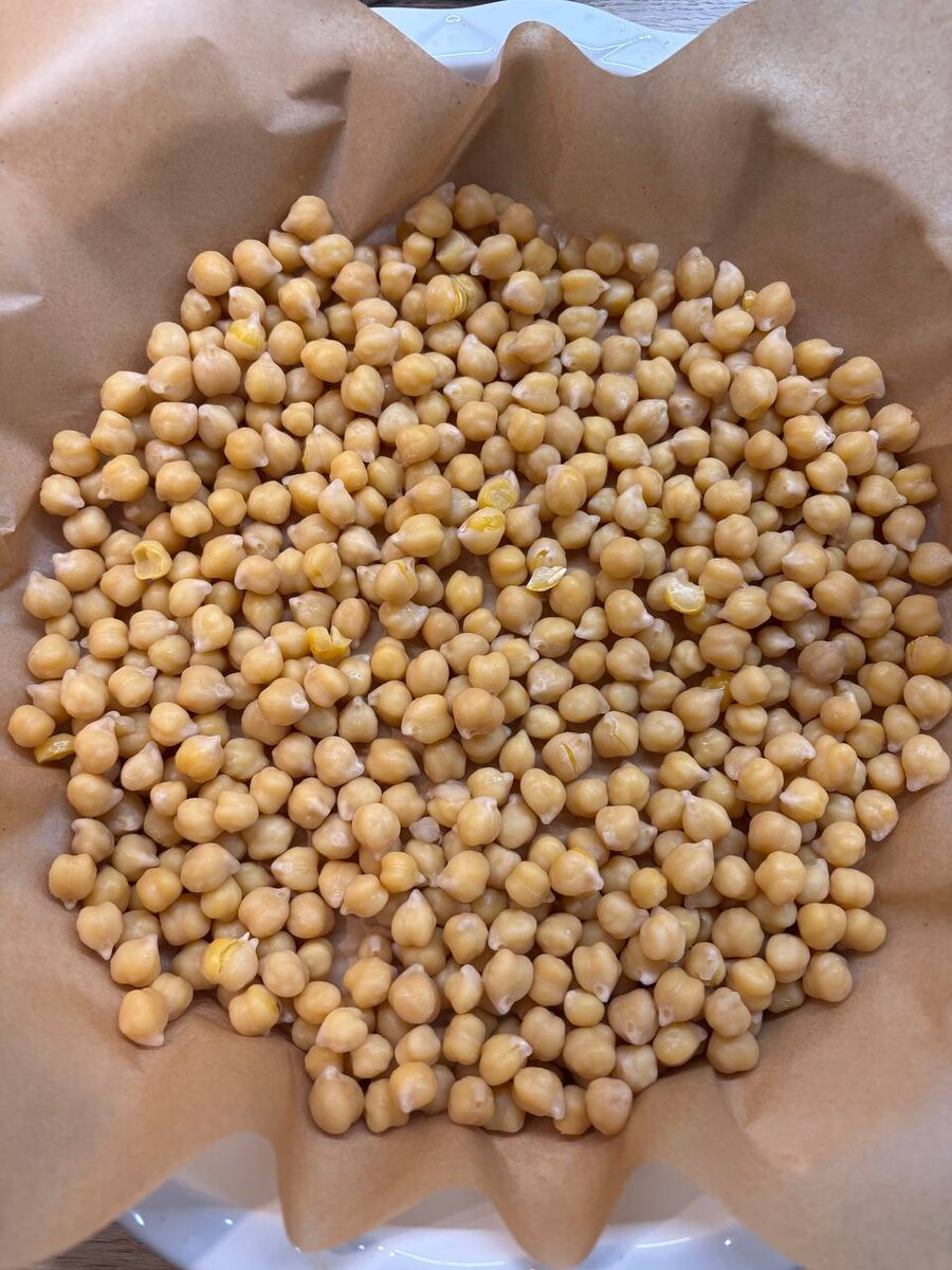 Заранее отварить нут и высыпать в форму для запекания, застелив бумагой для выпечки