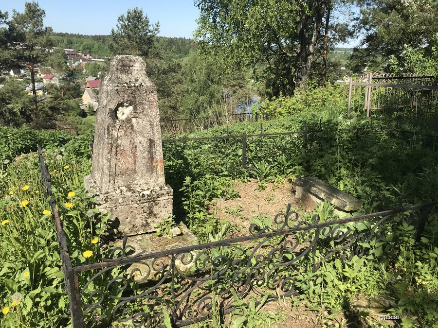 Известняковая стела XIX века с кованой оградкой. Внизу — река Лопасня