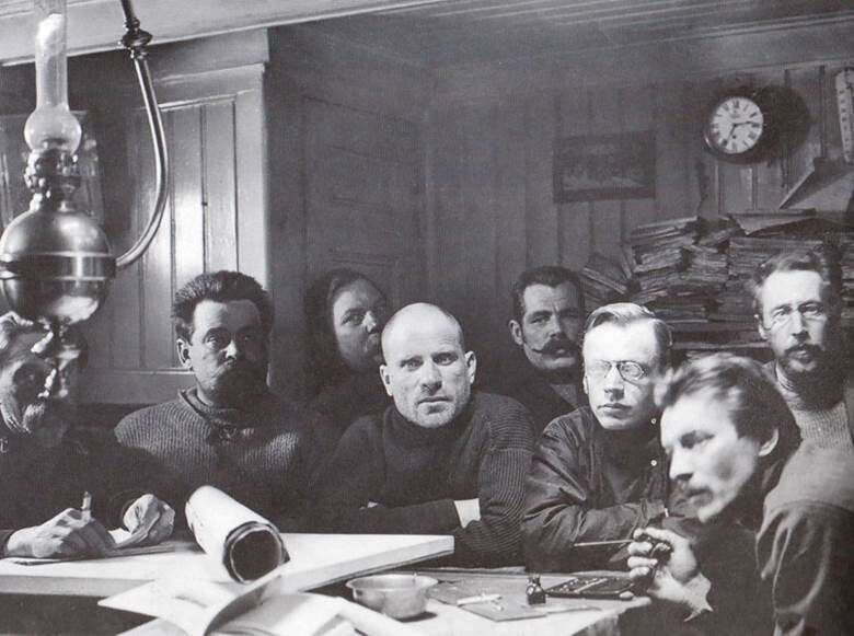 Группа участников экспедиции Г. Седова к Северному полюсу в кают-компании судна «Св. мученик Фока». На переднем плане начальник экспедиции Г. Седов (третий слева), метеоролог В. Визе, художник Н. Пинегин. Из кн.: «Русская Арктика: столетие в фотографиях» (Москва, 2015)