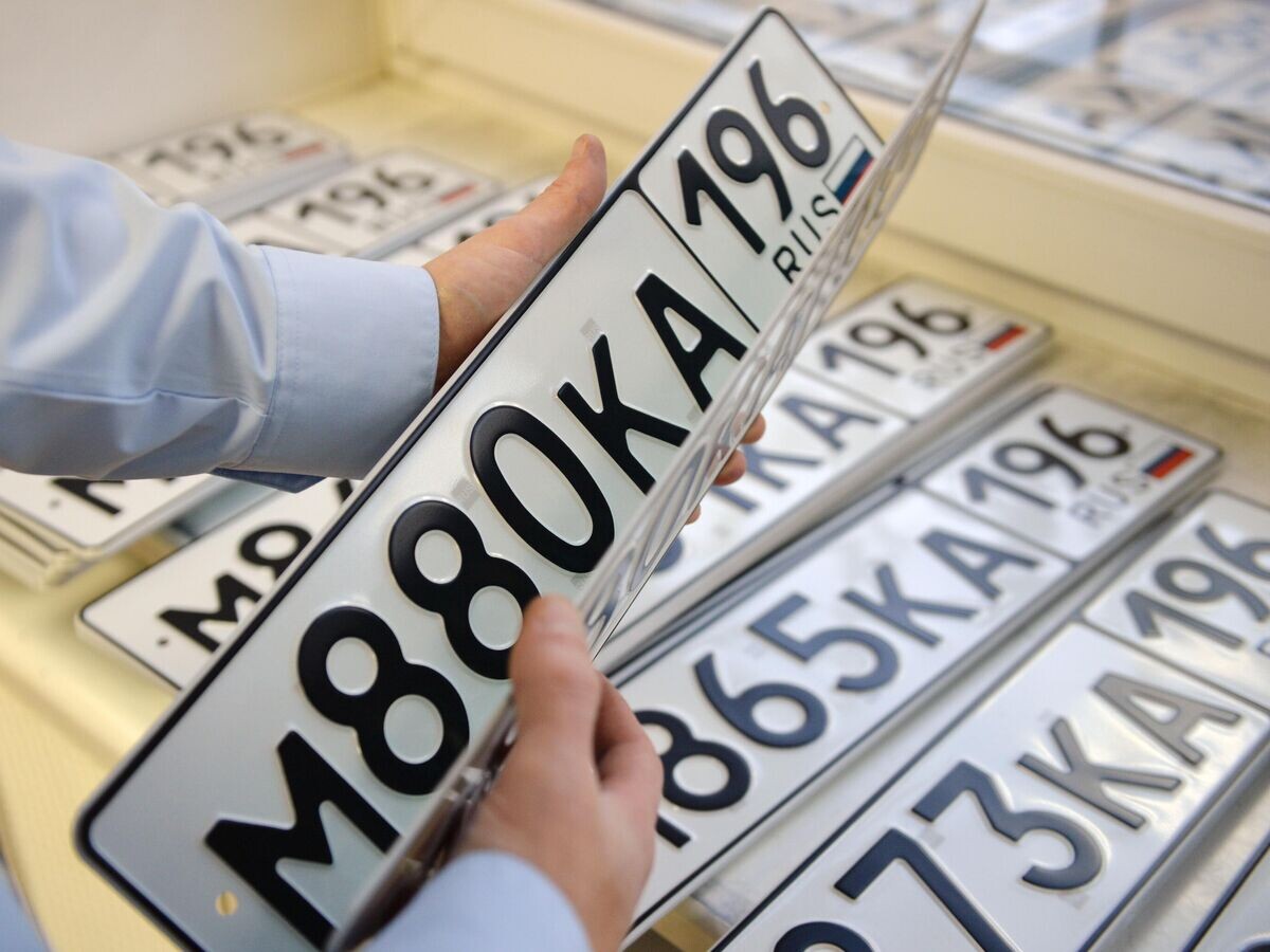    Сотрудник ГИБДД демонстрирует индивидуальные регистрационные знаки | © РИА Новости / Павел Лисицын
