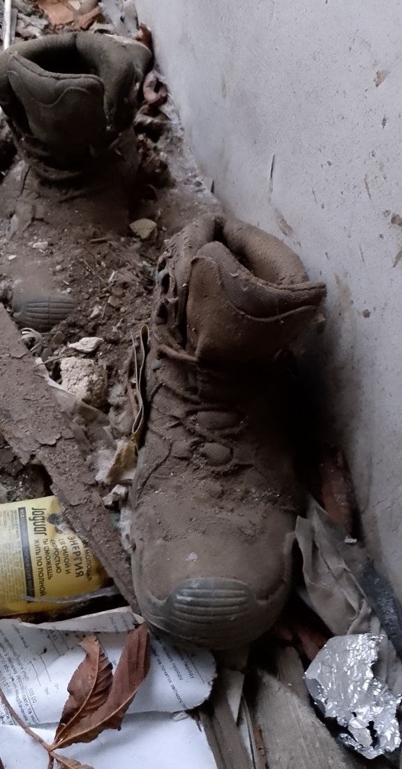 Фото автора: На пороге — солдатские ботинки. Они не стоят, они почти лежат, засыпанные строительным мусором, перемешанным с грязью. Кто их снял? Когда? Жив ли тот человек? Кто он?