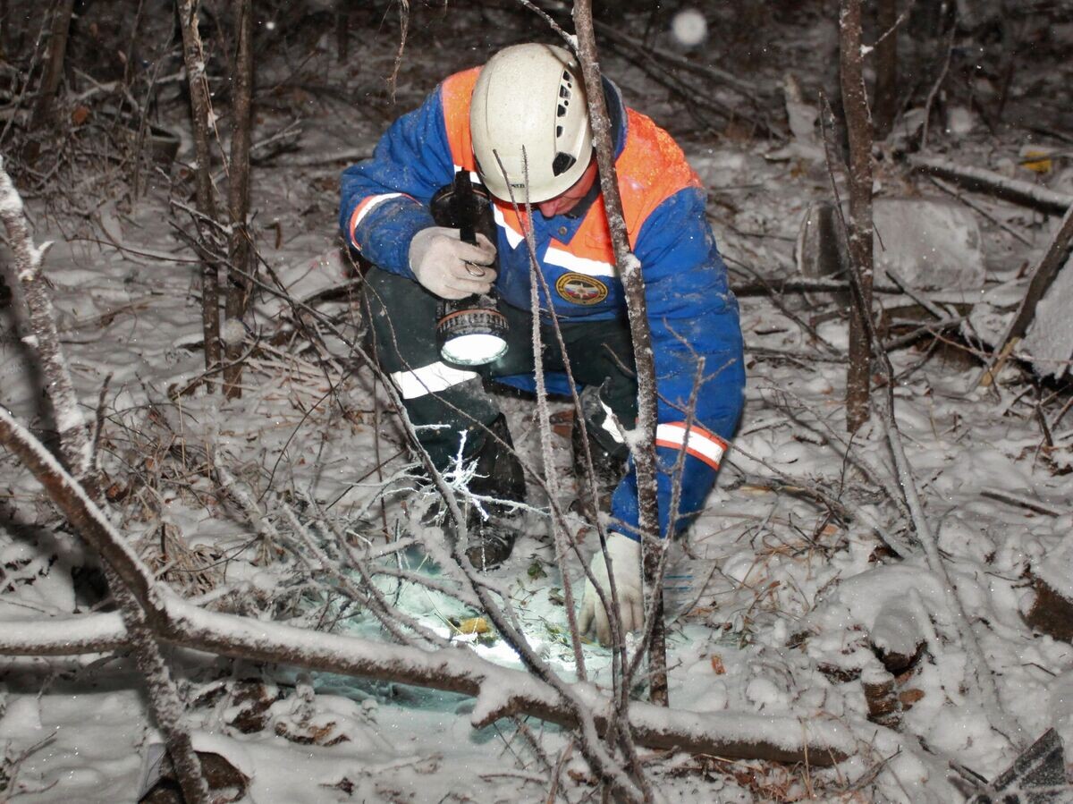    Сотрудник МЧС РФ ведет поиски на месте крушения самолета Ан-12 в Иркутской области | © РИА Новости / Кирилл Шипицин